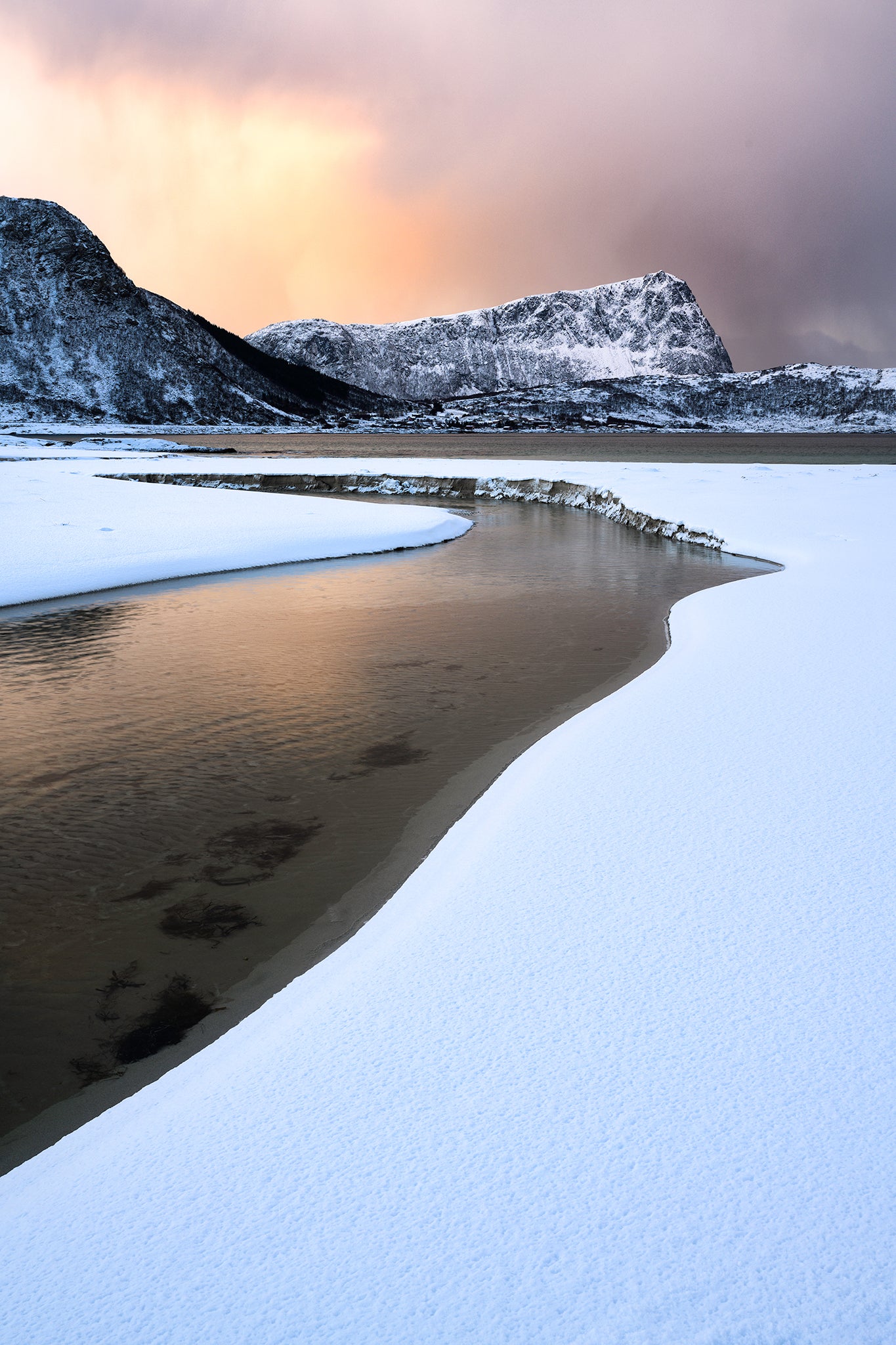 Reflective water surface with snow-covered mountains in the background
