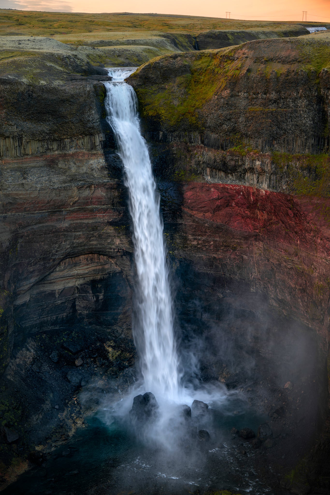 Haifoss Waterfall cascading down a cliff face with a red-brown hue