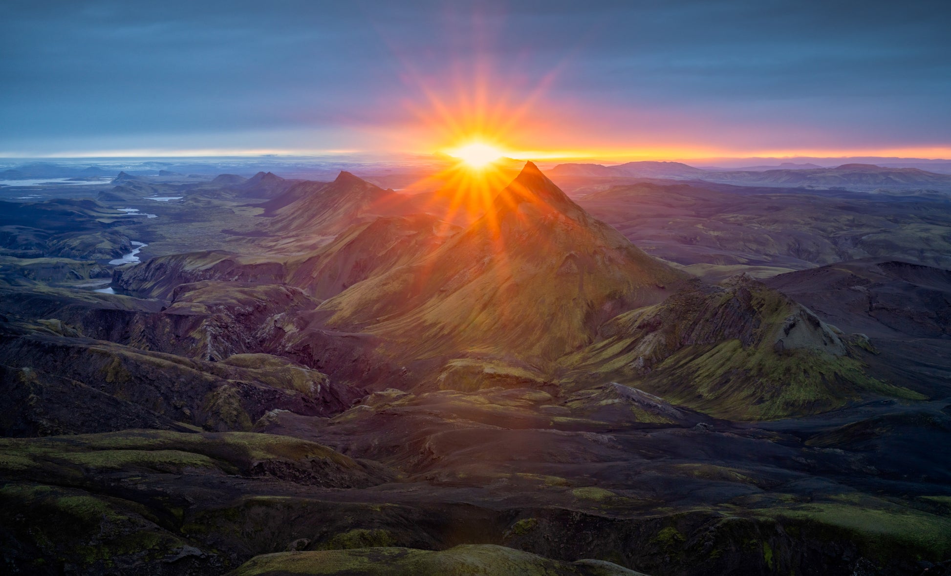 Iceland Highlands. Langisjor Region. Sunrise over a mountain range with a bright sun casting light on the landscape.