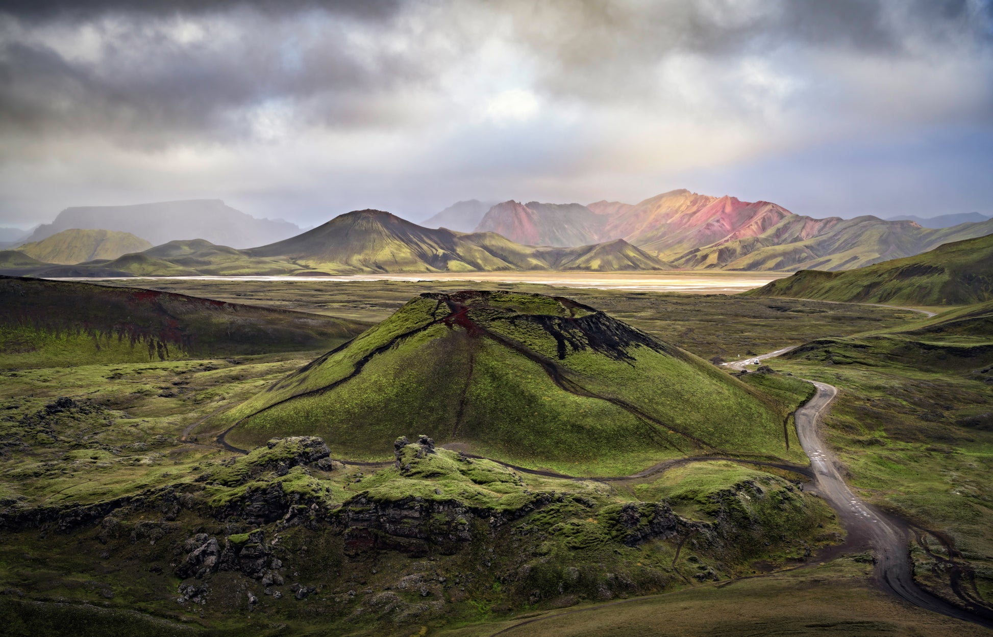 Stutur Volcano. Scenic view of a mountainous landscape with a road winding through green hills.