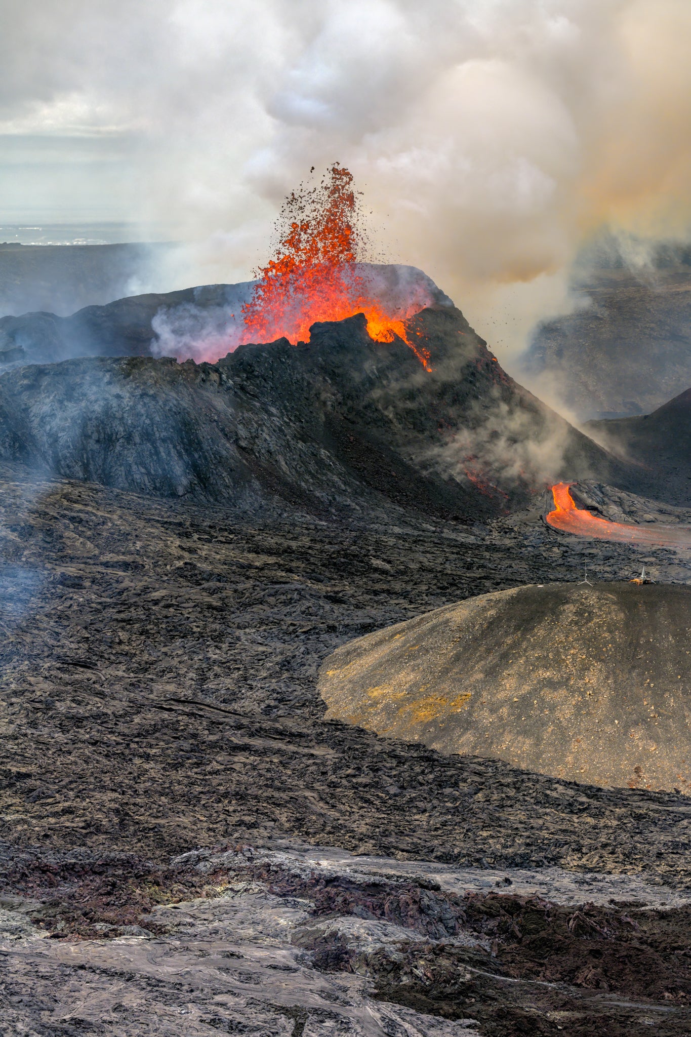 Geldingadalur Volcanic eruption with lava flowing and smoke rising from a mountain.